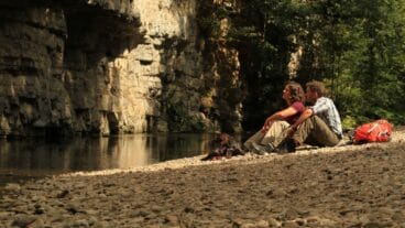 Multi-day hikers sitting by the Wutach River in the Wutach Gorge on the Schluchtensteig in the Schwarzwald