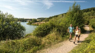 Two hikers on the AhrSteig walk past the Freilinger See