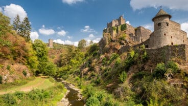 The Niederburg and Oberburg castles in Manderscheid viewed from the banks of the Lieser river