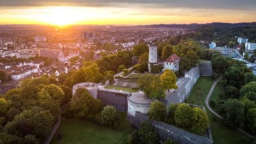 An aerial view of Bielefeld at sunrise with the Sparrenberg in the foreground
