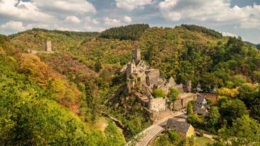 An autumn view of the Oberburg and Niederburg castle ruins in Manderschied from the Lieserpfad